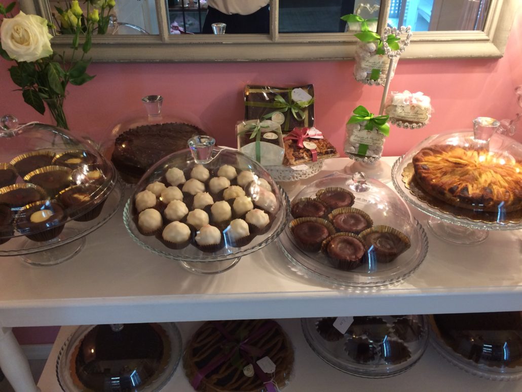 Il tavolo dei dolci del giorno: pasticcini sotto le campane di vetro, tortine di cioccolato, crostata e pacchetti regalo
